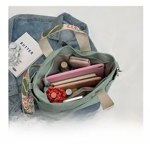 Detail of spacious interior layout in canvas tote bag showing items like tablet and umbrella