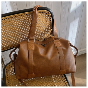 Détails du sac cabas en cuir PU marron avec doubles anses sur une chaise en rotin