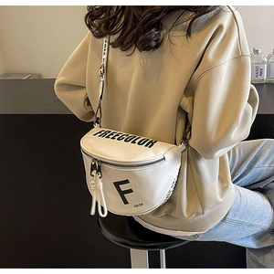 Detailed back view of a minimalist cream leather crossbody chest bag with adjustable strap