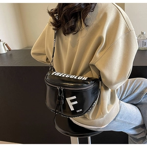 Detail of black leather saddle bag with white letter print and logo nylon shoulder strap