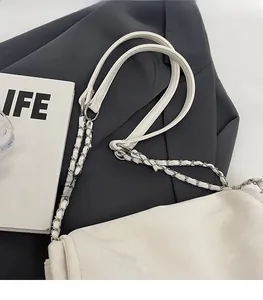 Detail of soft cream leather shoulder bag strap with silver chain and metal buckle