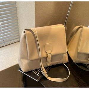 Detail of beige vintage crossbody bag showing smooth leather texture and gold buckle