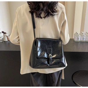 Detail of a black vintage wrinkled texture shoulder bag with silver buckle and flap closure