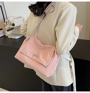 Detail of pink matte tote bag with silver chain strap shown on a model's shoulder