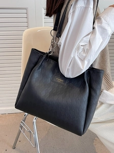 Chic black quilted tote bag with silver chain strap shown from a 45-degree angle view