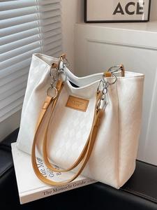 Minimalist white quilted tote bag with brown handles and fashion tag for daily commute