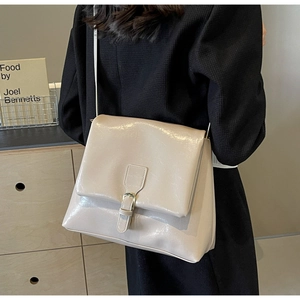 Detail of cream crossbody tote bag with silver square buckle and smooth leather texture