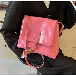 Detail of pink glossy patent leather tote with wrinkled texture and buckle closure