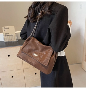 Vintage brown tote bag detail with distressed leather texture and metal chain strap