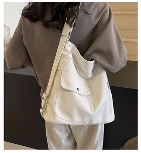 Detail view of large white PU canvas tote with functional multiple pockets and wide strap