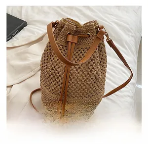 Detail of woven straw bucket bag showing leather drawstring and textured hollow pattern