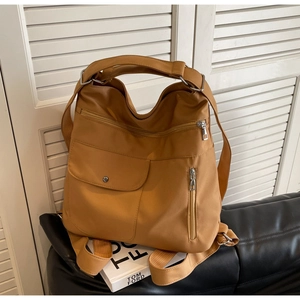 Detail of caramel nylon backpack featuring multiple functional pockets and durable straps