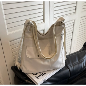 Detail of white PU leather tote backpack with multiple zippers and front flap pocket