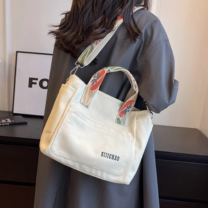 Canvas tote bag with floral embroidered strap and crossbody functionality for women
