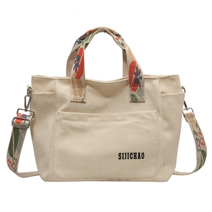 Off-white canvas tote bag with floral print wide shoulder strap and spacious front pocket