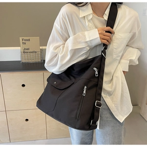 Detail of black large capacity nylon tote with multiple pockets and adjustable strap