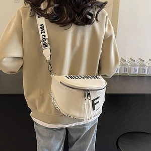White crescent crossbody bag with wide FREECOLOR logo strap shown on model's back
