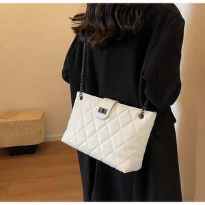 Vista posteriore di una modella con borsa trapuntata bianca e chiusura a rotazione