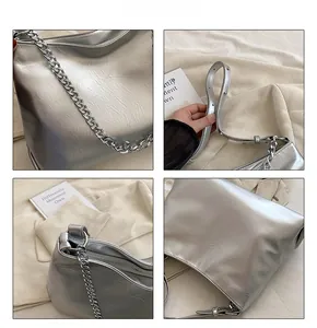 Macro shot of silver crinkled leather texture and metallic chain detail on tote bag
