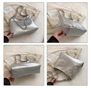 Detail of silver metallic tote bag with chunky metal chain and textured PU leather finish