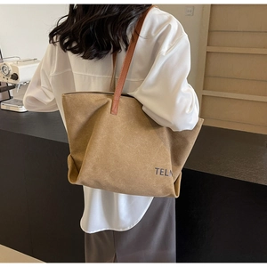 Khaki canvas tote bag with brown leather shoulder straps worn by model for daily commute