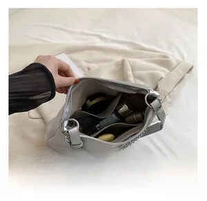 Detailed interior of the silver tote bag showing spacious capacity and inner pockets