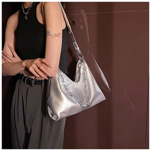 Detail of silver metallic tote bag featuring chunky metal chain and wrinkled texture