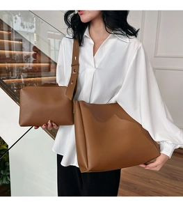 Close-up of caramel leather tote bag set including a large shoulder bag and small pouch