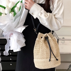 Minimalist straw bucket bag with woven hollow texture and black drawstring for vacation
