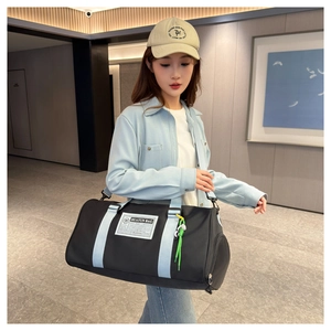 Detail of black Oxford travel bag featuring light blue straps and a brand label