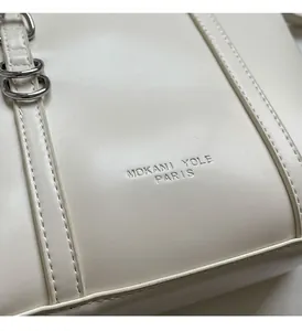 Close-up of cream leather tote bag with silver logo and precise stitching details