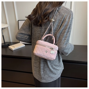 Détail du mini sac matelassé rose avec breloque camélia argentée et bandoulière chaîne