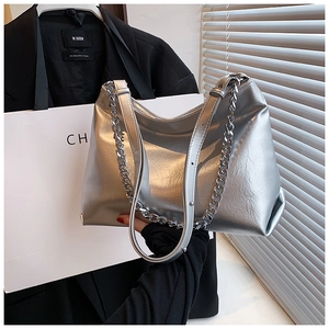 Detail of silver metallic tote bag featuring pleated texture and chunky chain strap
