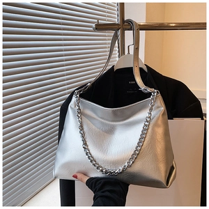 Detail of silver metallic tote bag with pleated texture and chunky chain strap