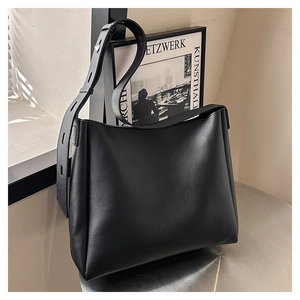 Close-up of black matte leather tote bag with unique perforated wide shoulder strap