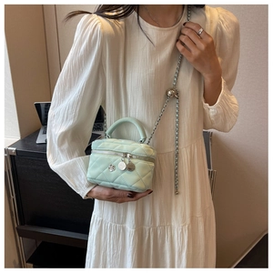 Mini sac seau matelassé vert menthe avec chaîne dorée et détail de breloque camélia