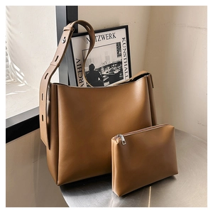 Detail of vintage camel brown bucket bag set with wide adjustable strap and inner pouch