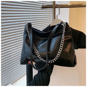 Detail of black faux leather tote with chunky silver chain and adjustable shoulder strap