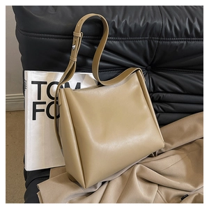 Detail of dark beige leather shoulder bag showing smooth texture and adjustable metal buckle