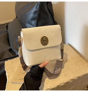 Détail du sac seau crème avec boucle en métal vintage ours et large bandoulière brodée