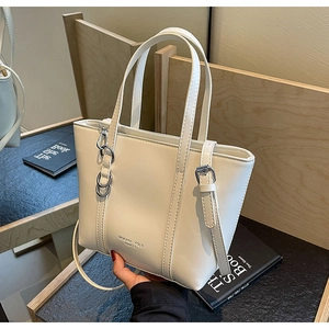 Detail of cream tote bag featuring silver ring hardware and Mokani Yole brand logo
