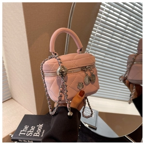 Détail d'un mini sac rose matelassé avec chaîne argentée et charms floraux élégants
