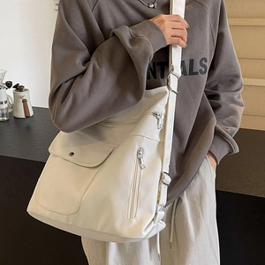 Large beige multi-pocket tote bag with adjustable strap and polished metal zippers