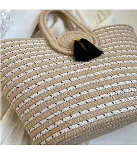 Detailed close-up of woven rope tote bag with black tassel and striped texture