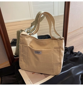 Detail of canvas tote bag with front pocket and logo in a stylish home setting