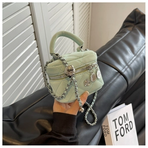 Détail du mini sac matelassé vert menthe avec chaîne argentée et breloque fleurie