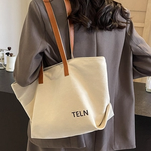 Minimalist canvas tote bag with brown leather straps and TELN print for daily commuting