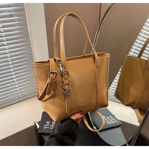 Close-up of caramel tote bag with silver metal branding and adjustable strap buckle