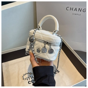 Détail du mini sac seau matelassé blanc avec bandoulière chaîne et breloques fleurs