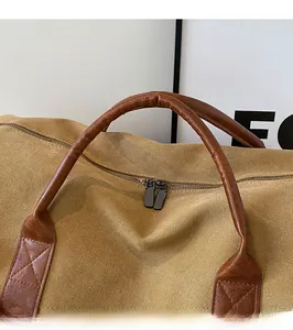 Detail of durable brown leather handle with reinforced stitching on khaki canvas travel bag